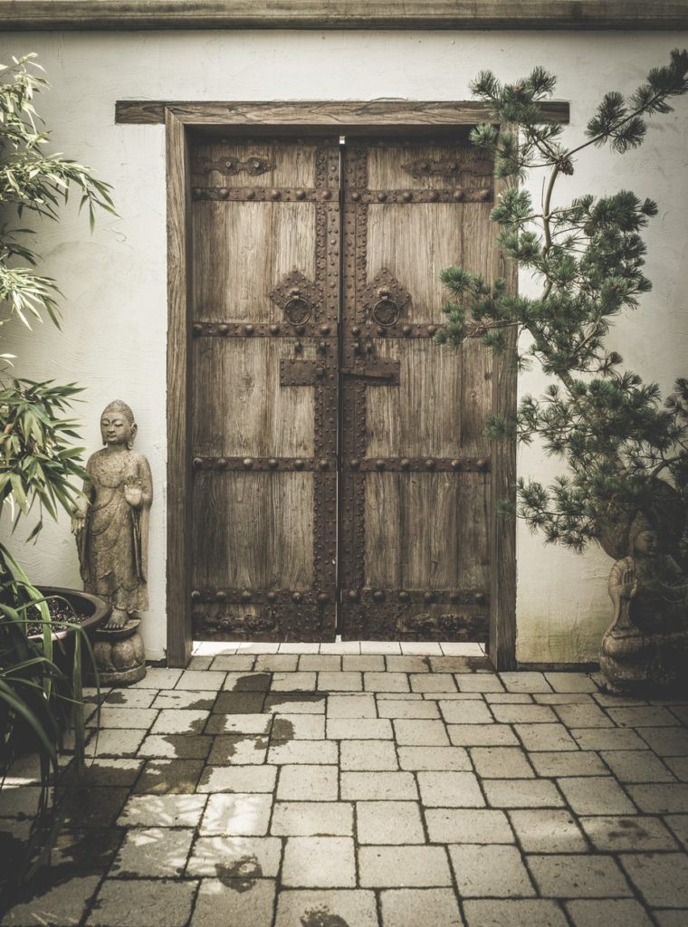 Porte en bois ornée de deux bouddhas.
